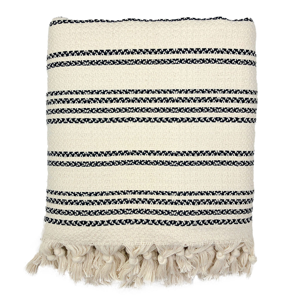 A cozy Woven Stripe Turkish Throw featuring intricate stripe patterns and hand-knotted fringe, perfect for home decor.