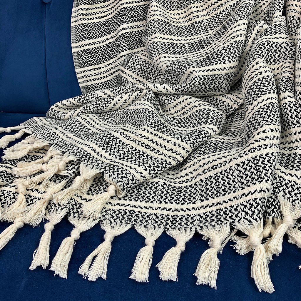 A cozy Woven Stripe Turkish Throw featuring intricate stripe patterns and hand-knotted fringe, perfect for home decor.