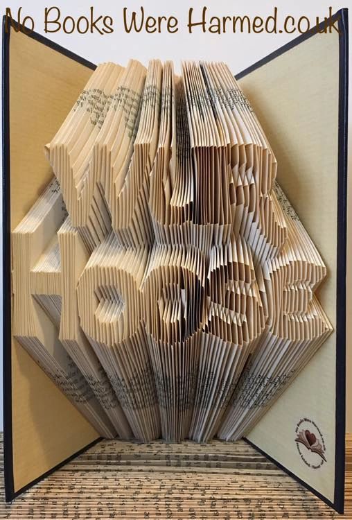 A beautifully crafted Wur Hoose art piece made from hand-folded pages of vintage books, showcasing intricate designs and unique colors.