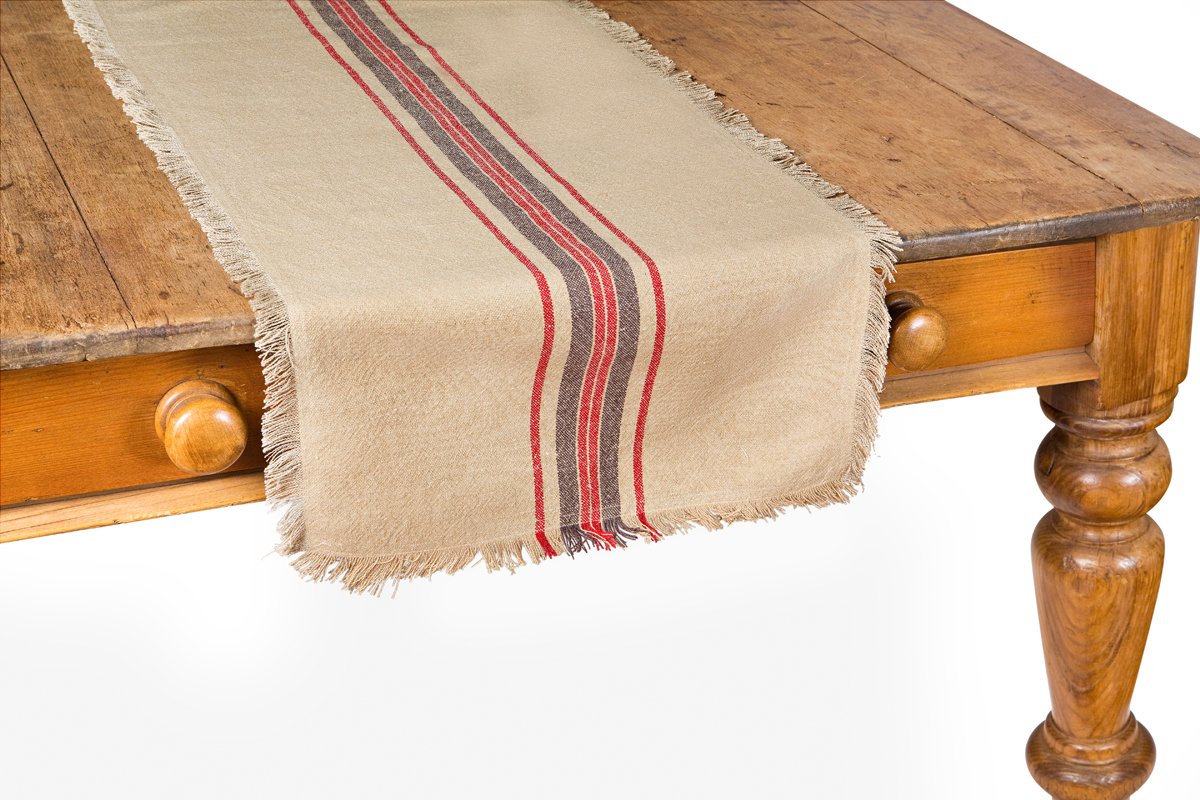 Natural linen stripe table runner with frayed edges, showcasing a rustic design suitable for various table settings.