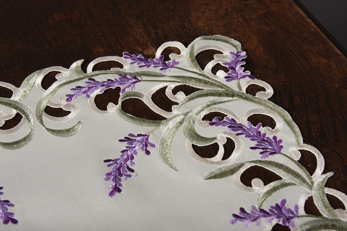 Elegant lavender lace table runner with scalloped edges and green embroidery, perfect for enhancing table settings.