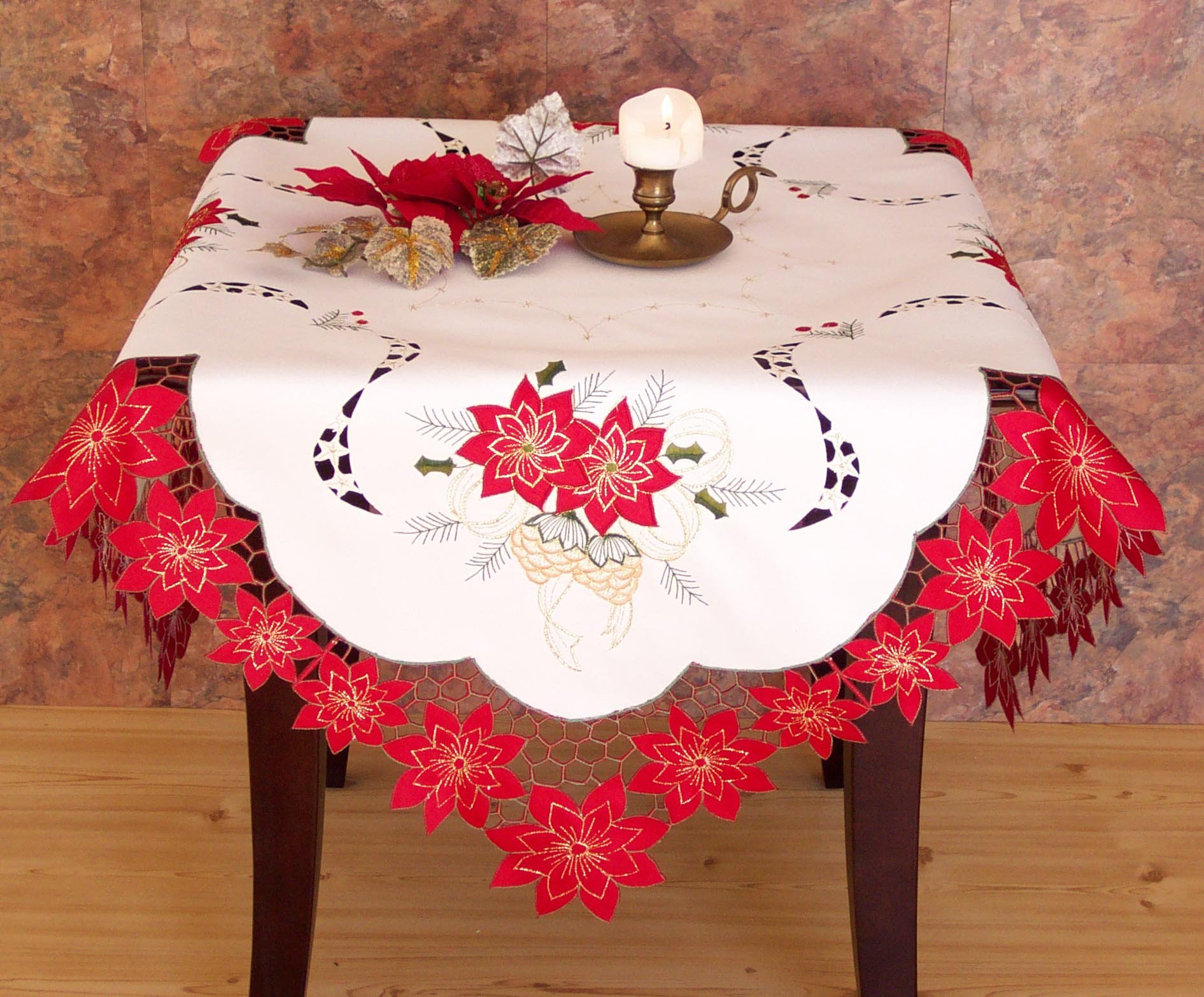 XD46227 Celebration Collection table linens featuring embroidered poinsettias and pinecones with a cutwork poinsettia border.