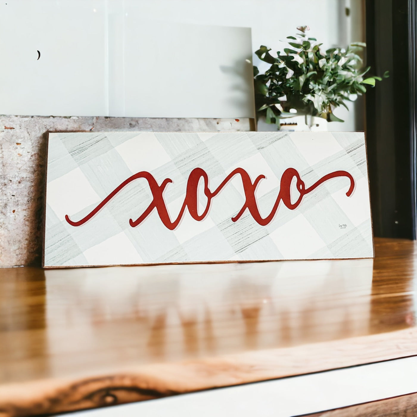 Handmade XOXO Sign made of thick wood with a light gray and white checkered background and darker red script, perfect for Valentine's Day decor.