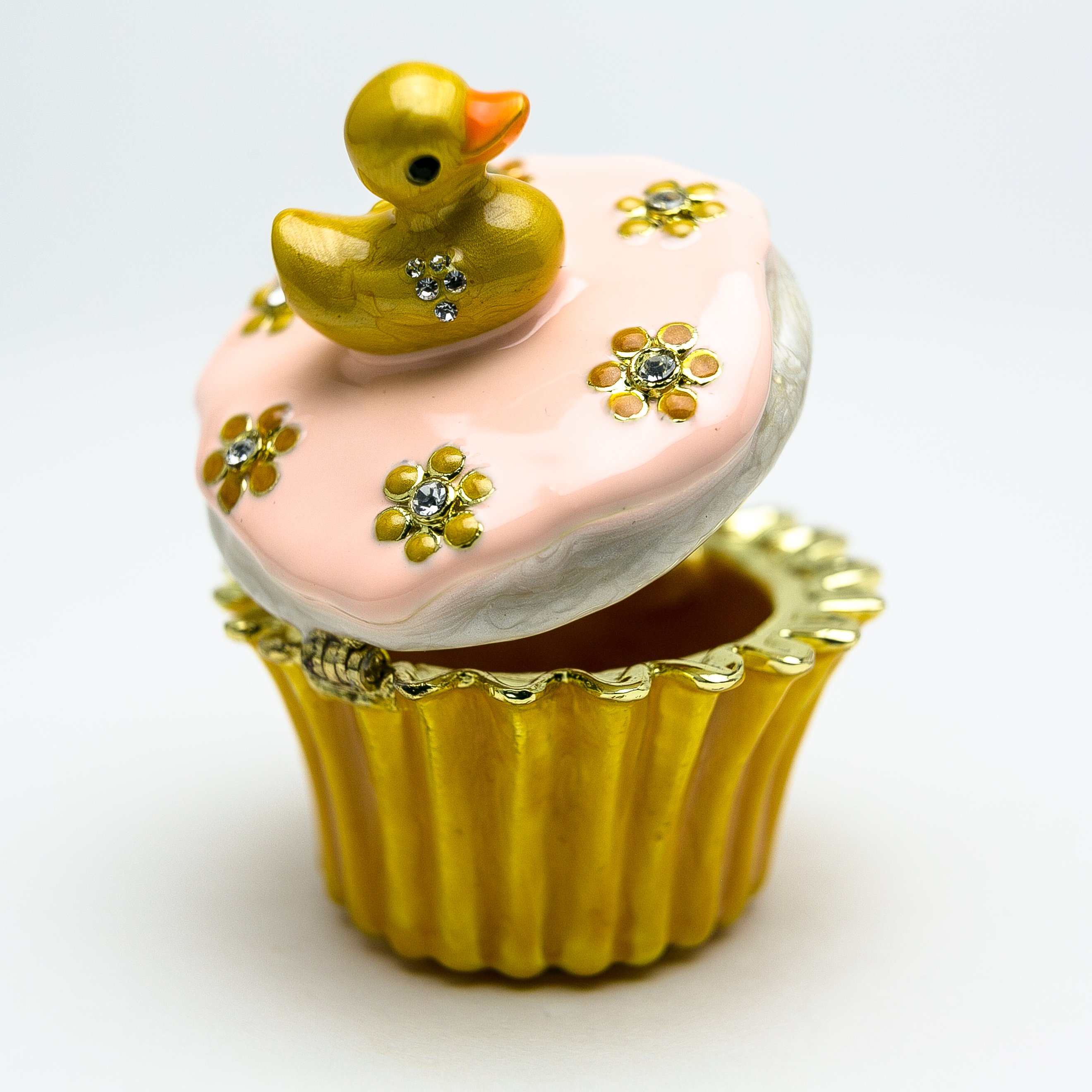 A beautifully handcrafted trinket box featuring a yellow duck on a cupcake, adorned with Austrian crystals and 24K gold plating.