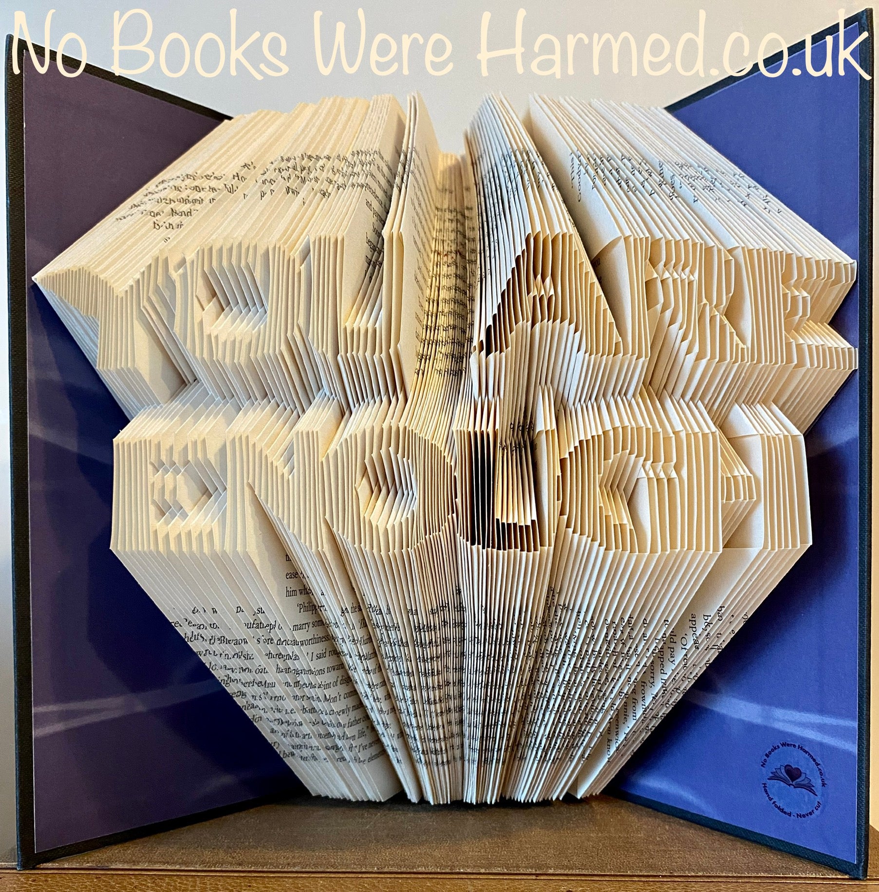 A beautifully handcrafted book art piece titled 'You are Enough', made from vintage book pages, showcasing intricate hand-folded designs.