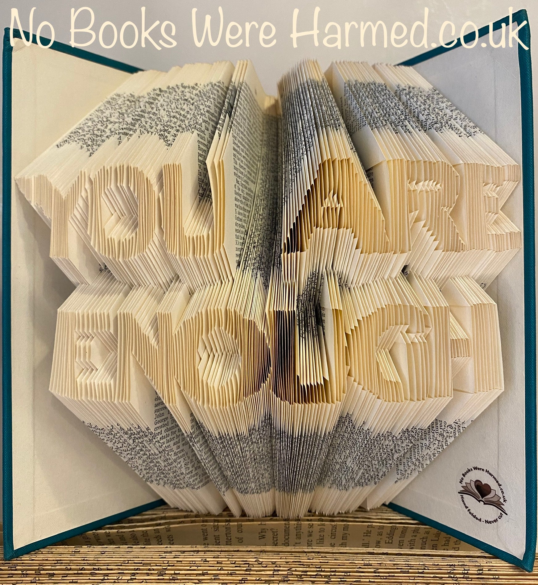 A beautifully handcrafted book art piece titled 'You are Enough', made from vintage book pages, showcasing intricate hand-folded designs.