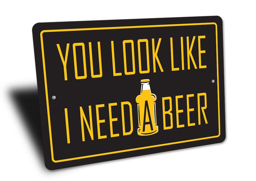 You Look Like I Need a Beer Sign made of high-quality aluminum, featuring humorous text, ideal for home bars and man caves.