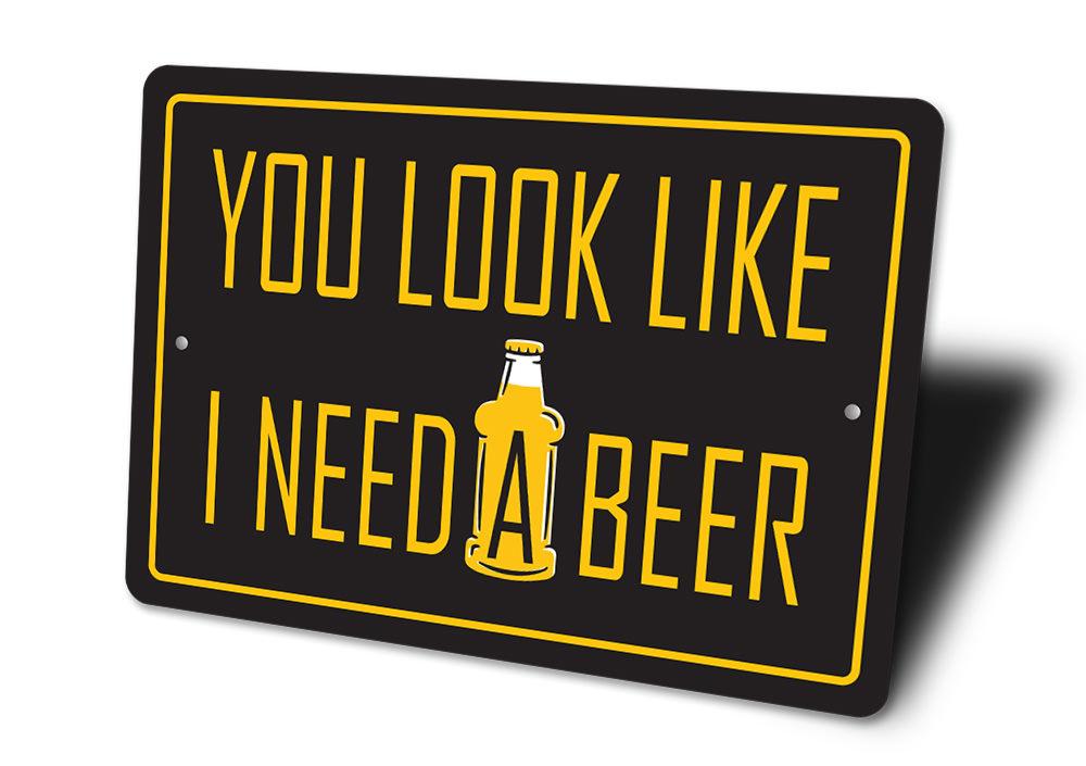 You Look Like I Need a Beer Sign made of high-quality aluminum, featuring humorous text, ideal for home bars and man caves.