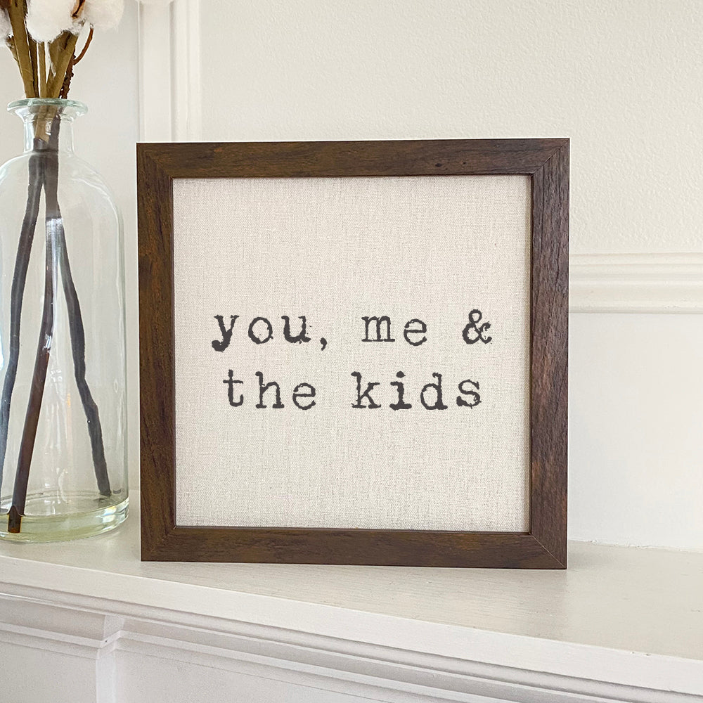 You, Me and... Framed Sign with a stylized wood frame and linen-look background, perfect for home decor.