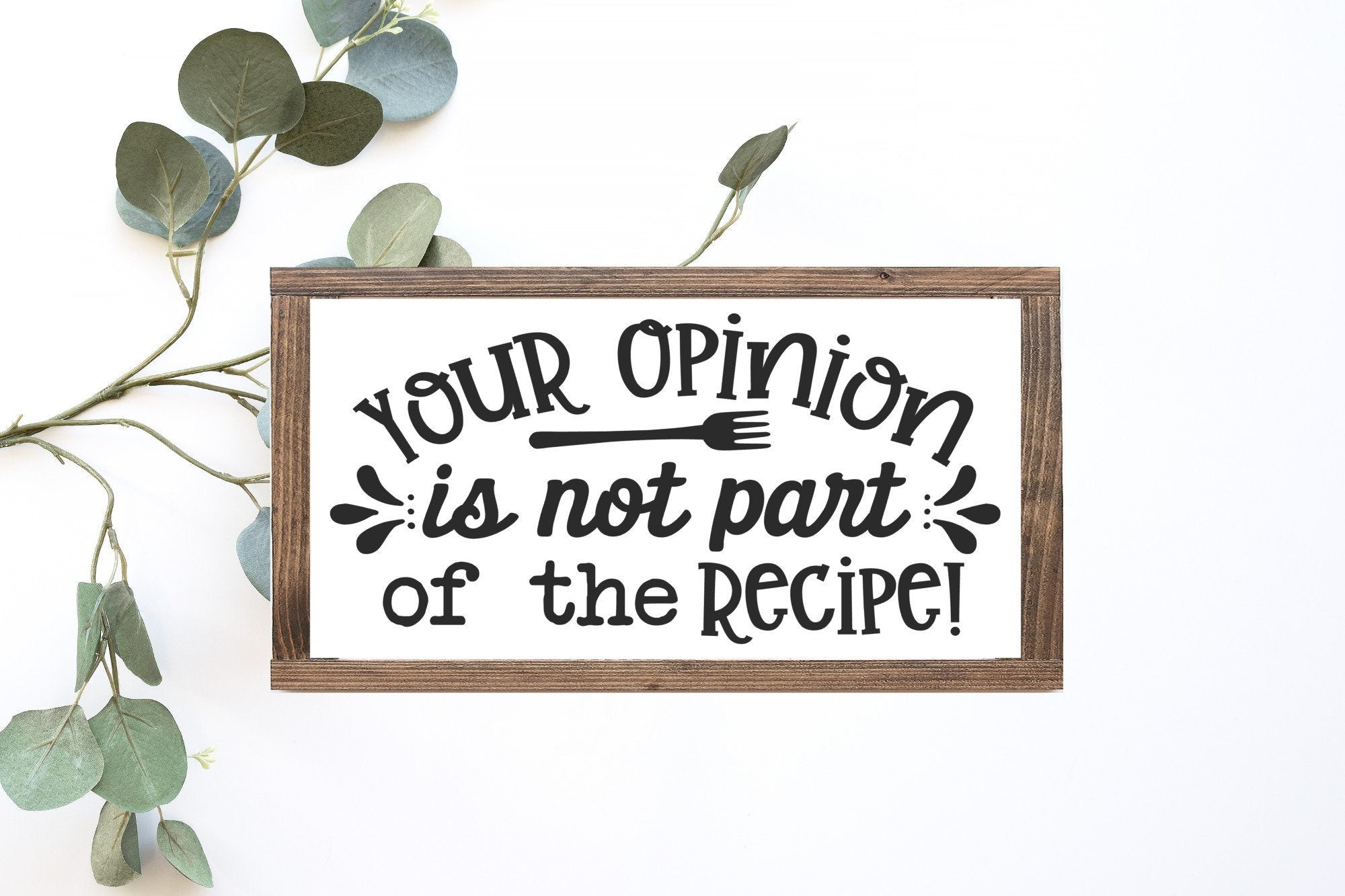 A rustic wooden sign with the phrase 'Your Opinion Is Not Part Of The Recipe' painted in black on a matte white background, showcasing its handmade quality.