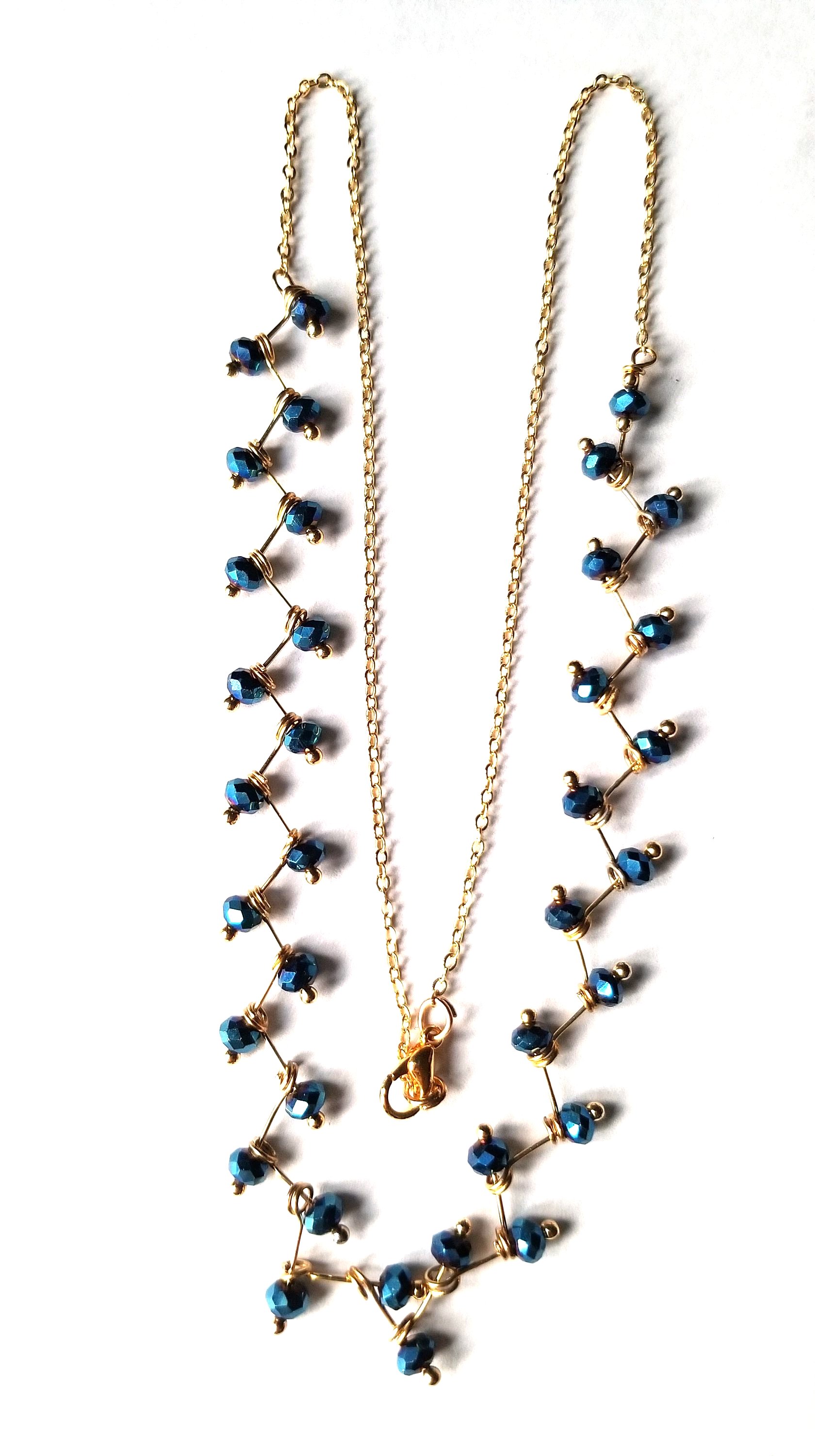 Zig Zag Blue Jewelry Set featuring a chain, bracelet, and earrings with shining blue beads and gold plating.