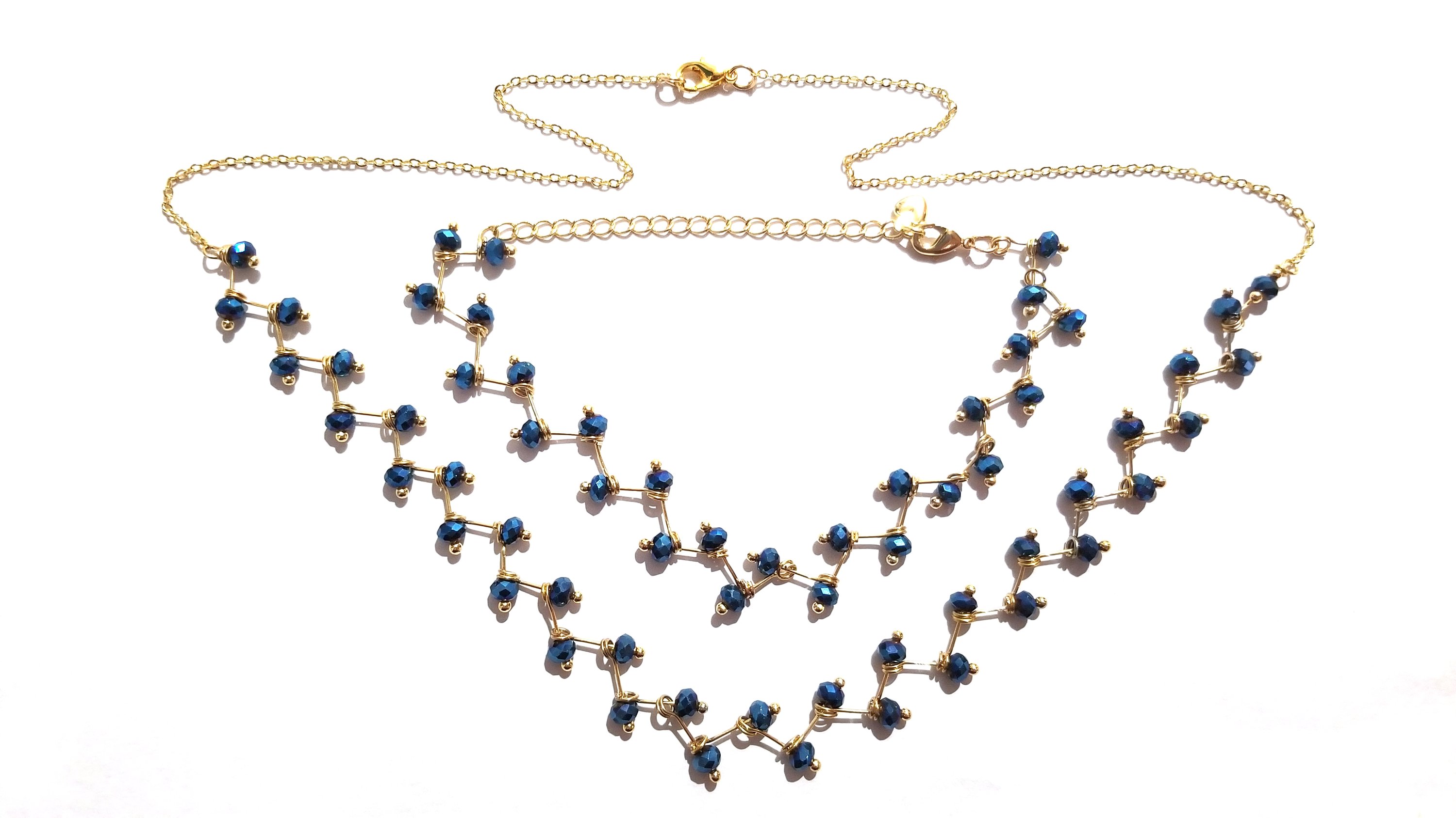 Zig Zag Blue Jewelry Set featuring a chain, bracelet, and earrings with shining blue beads and gold plating.