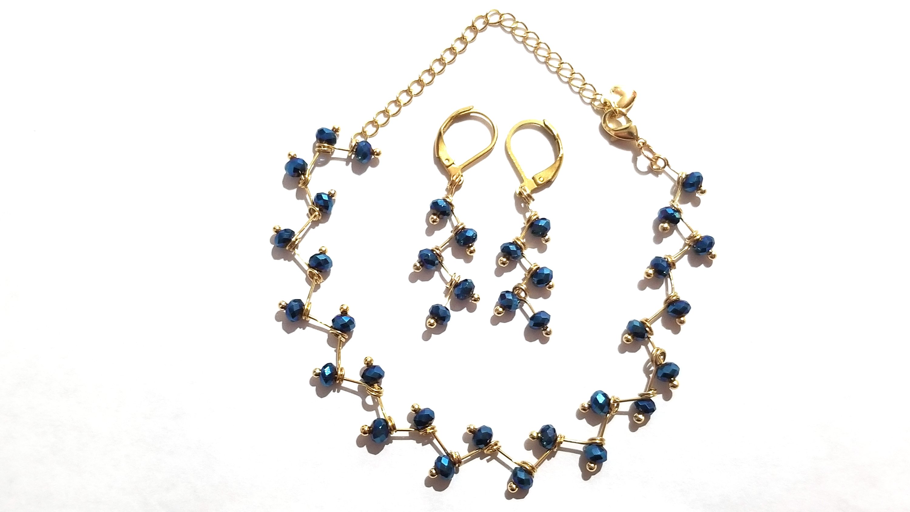 Zig Zag Blue Jewelry Set featuring a chain, bracelet, and earrings with shining blue beads and gold plating.