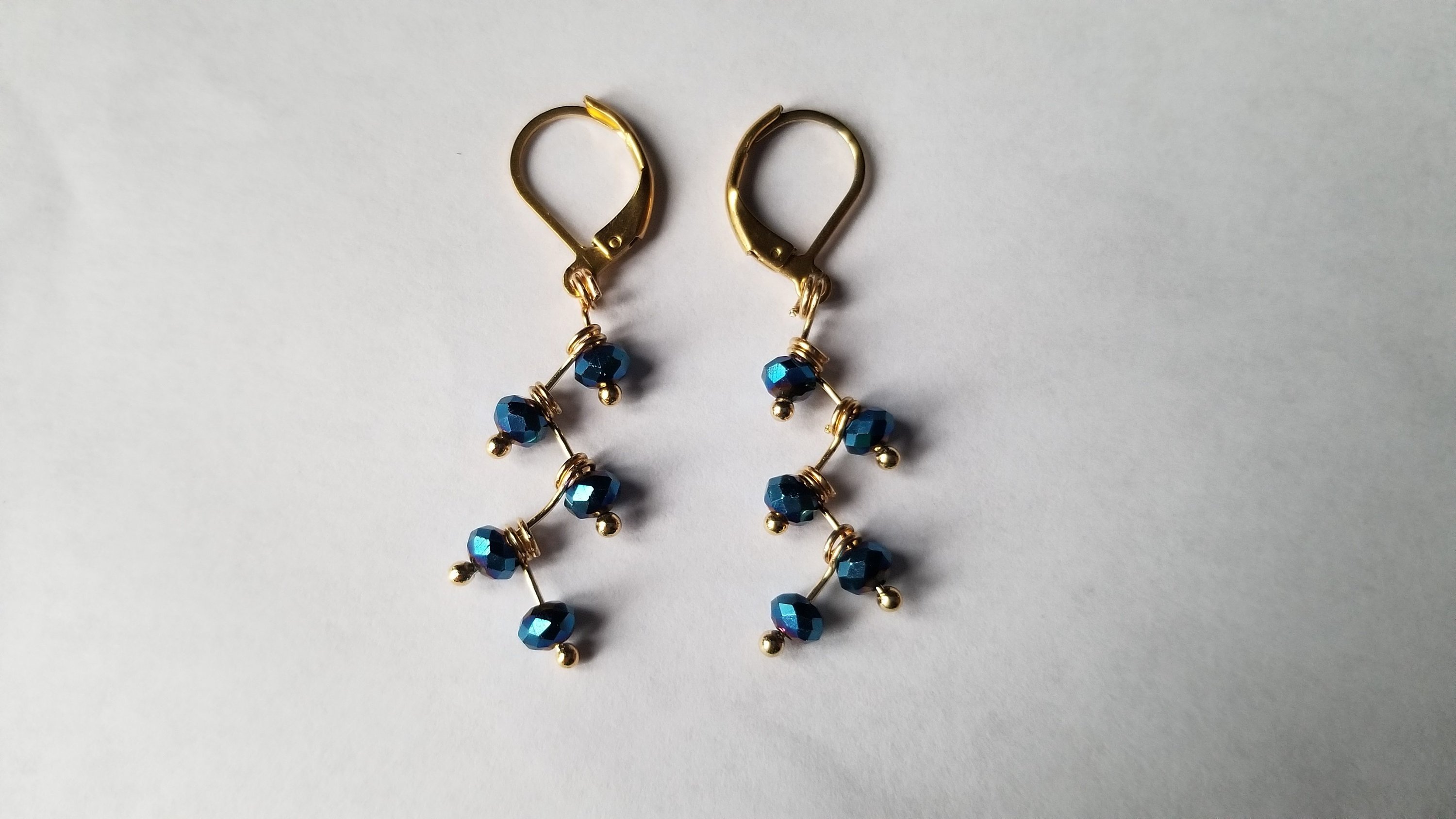 Zig Zag Blue Jewelry Set featuring a chain, bracelet, and earrings with shining blue beads and gold plating.