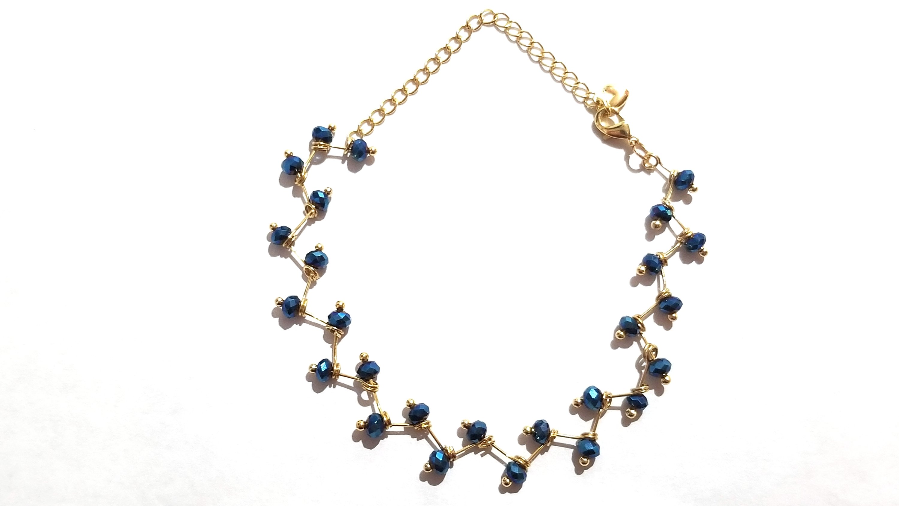 Zig Zag Blue Jewelry Set featuring a chain, bracelet, and earrings with shining blue beads and gold plating.