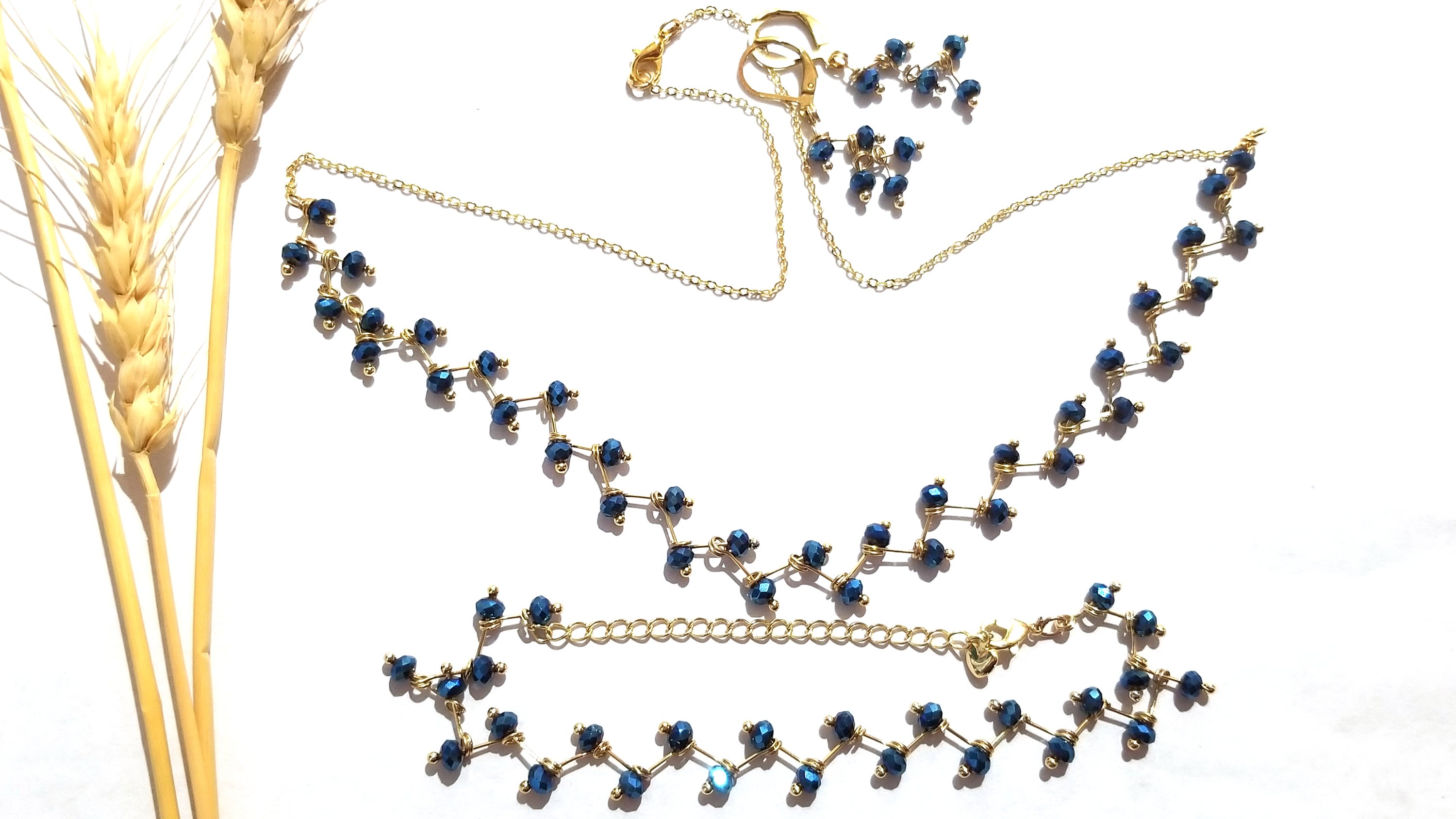 Zig Zag Blue Jewelry Set featuring a chain, bracelet, and earrings with shining blue beads and gold plating.