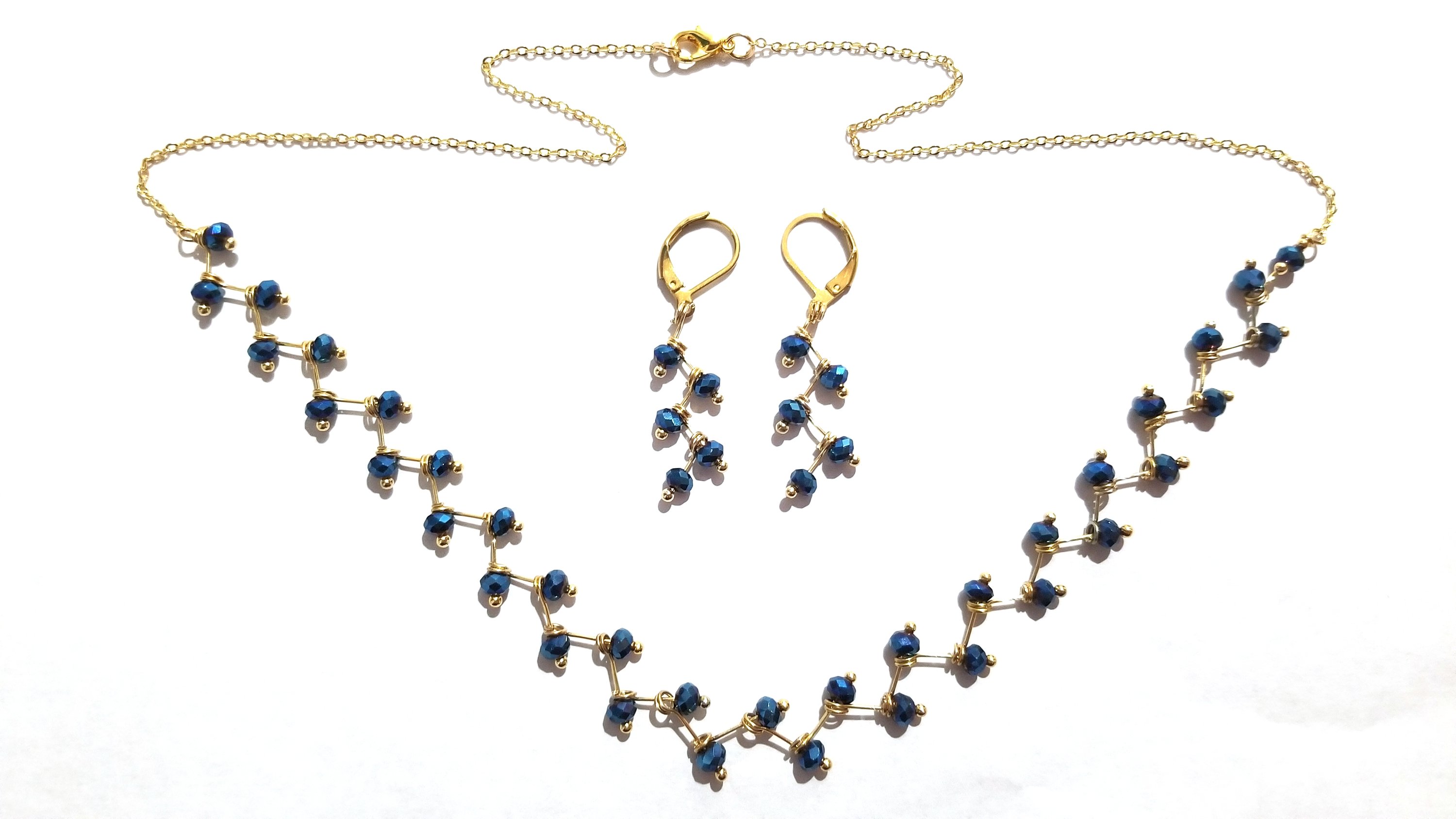 Zig Zag Blue Jewelry Set featuring a chain, bracelet, and earrings with shining blue beads and gold plating.