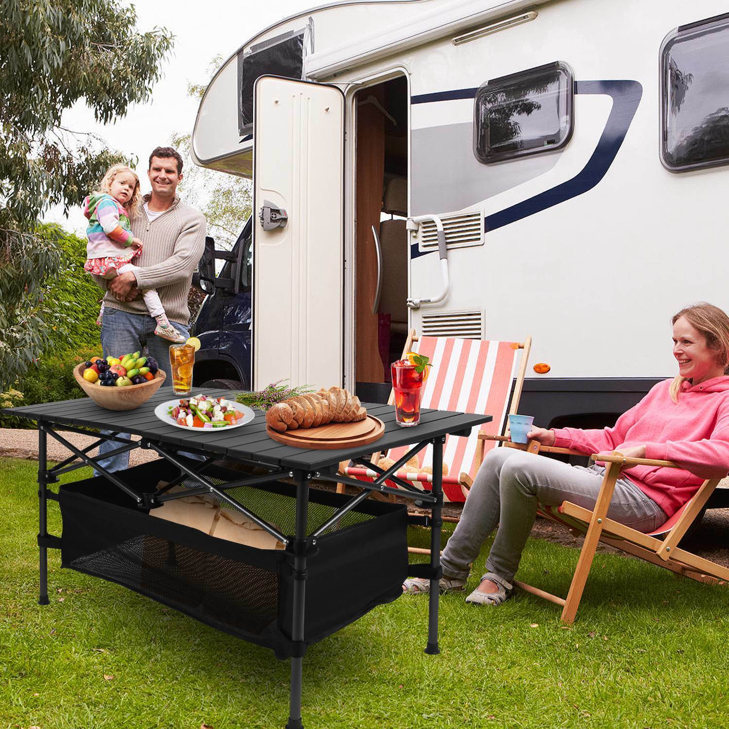 Lightweight aluminum folding camping table set up outdoors with a mesh storage basket underneath.