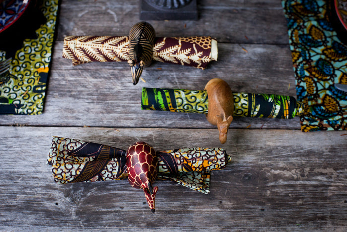 Set of six hand-carved African wooden napkin rings featuring giraffe, elephant, cheetah, zebra, rhino, and lion designs.