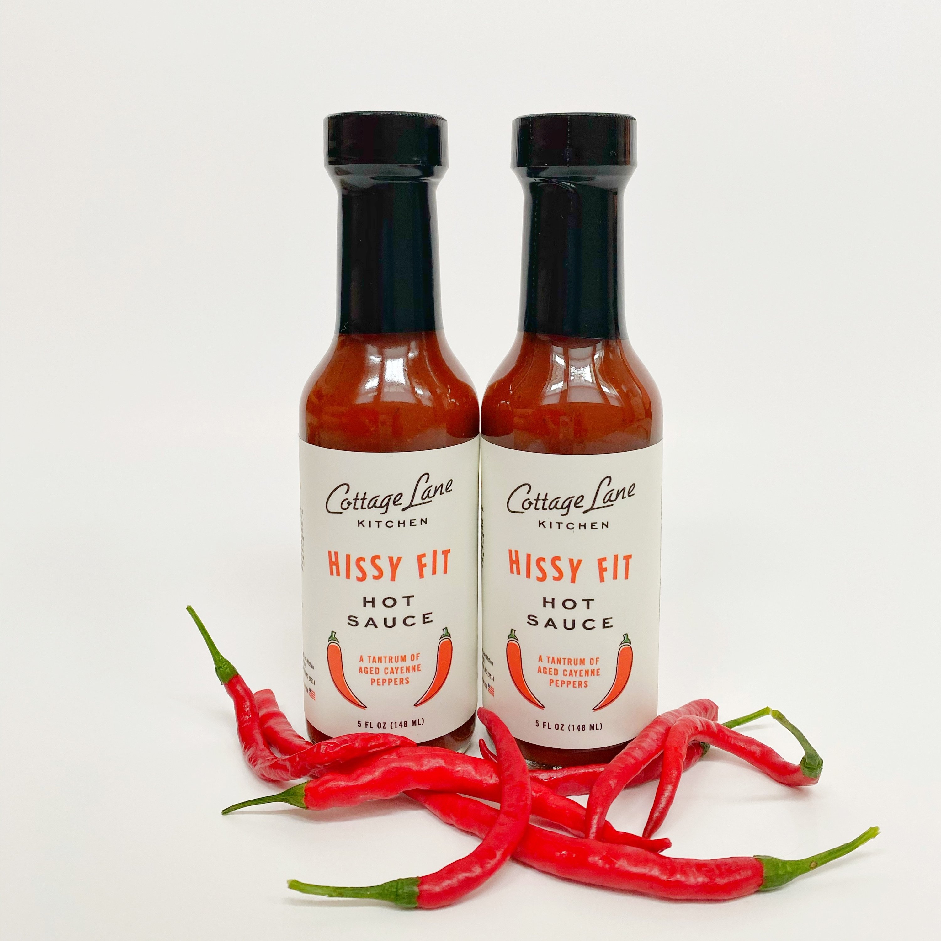 A case containing 12 bottles of Hissy Fit Hot Sauce, each bottle is 5oz, showcasing vibrant packaging and a spicy appeal.