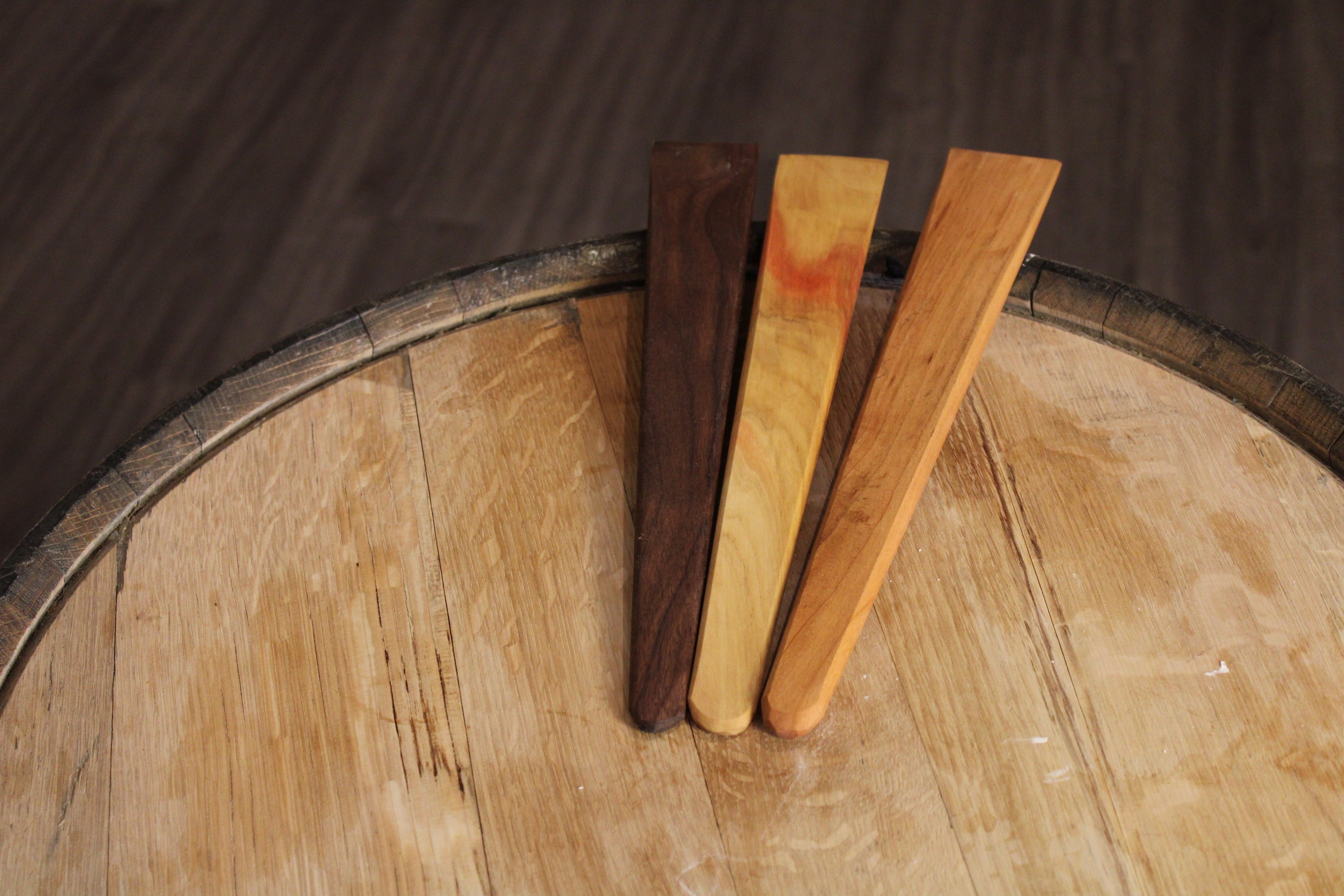 A 13-inch wooden spatula made from urban lumber, showcasing its thin design and beautiful wood grain in Cherry, Walnut, and Maple finishes.