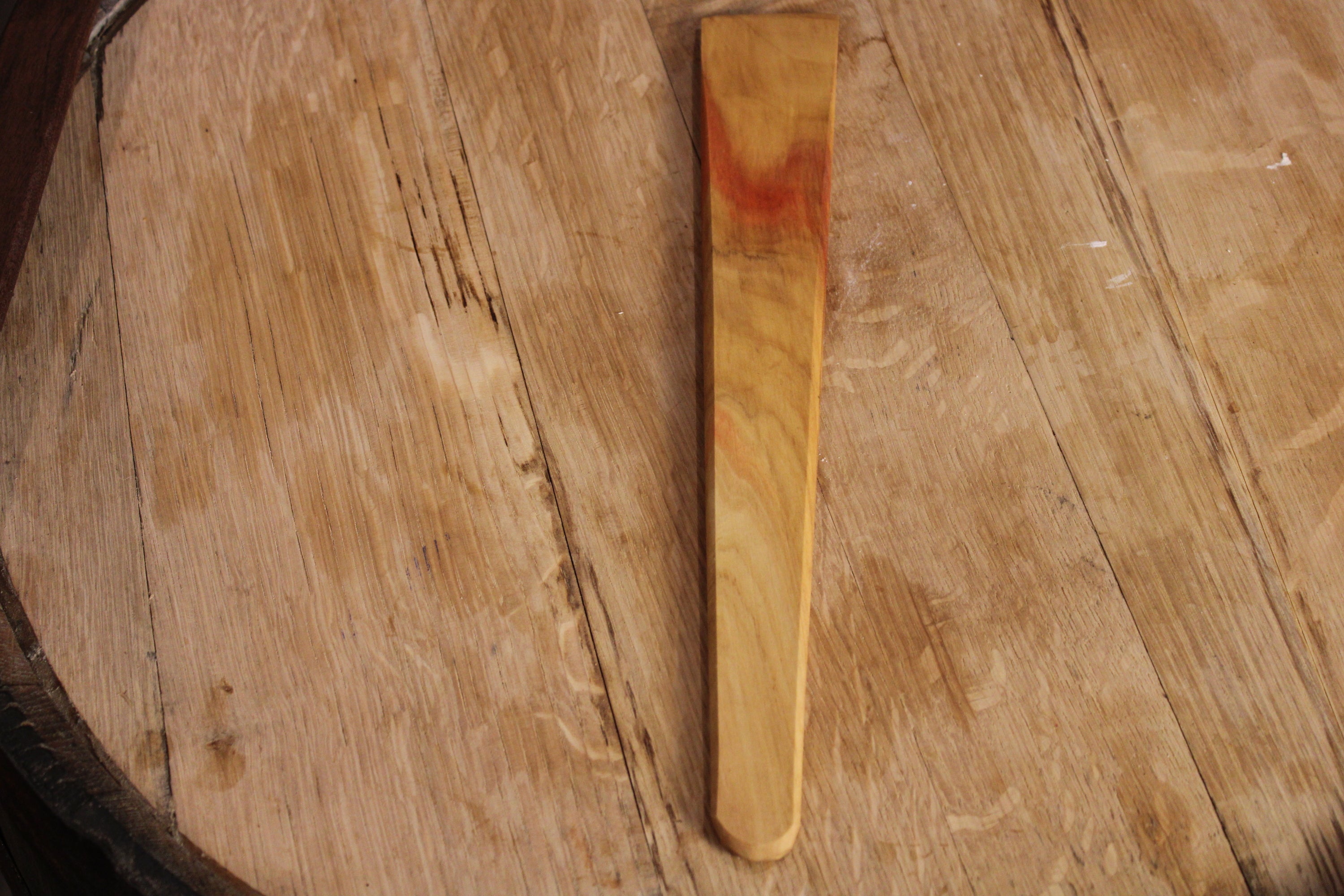 A 13-inch wooden spatula made from urban lumber, showcasing its thin design and beautiful wood grain in Cherry, Walnut, and Maple finishes.