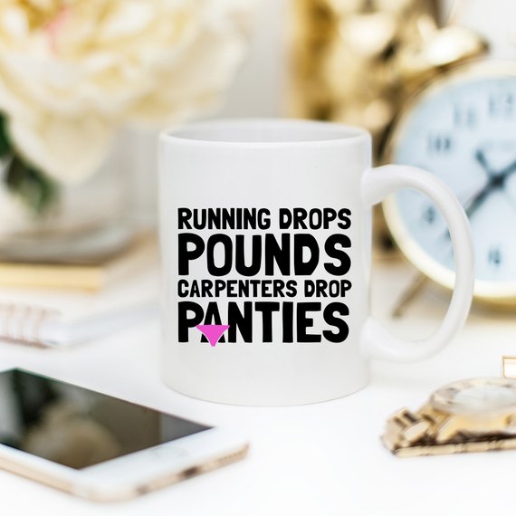 A humorous 11oz coffee mug featuring the phrase 'Running Drops Pounds, Carpenters Drop Panties' in a vibrant design.