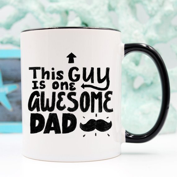 A humorous 11oz coffee mug with the text 'This Guy Is One Awesome Dad' printed on it, showcasing a fun design perfect for gifting.