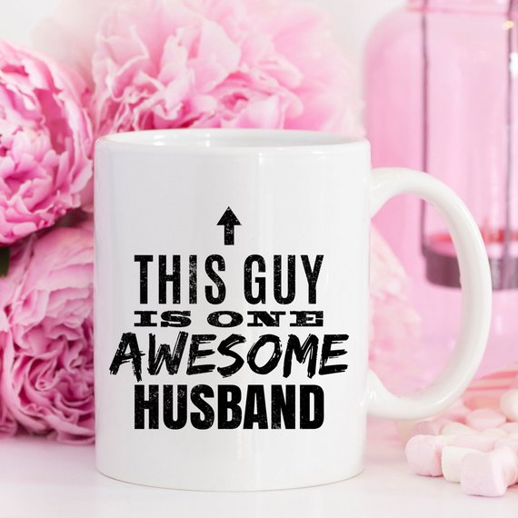 A humorous 11oz coffee mug with the text 'This Guy Is One Awesome Husband' printed on it, showcasing a fun design perfect for gifting.