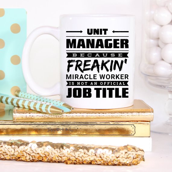 A humorous 11oz coffee mug featuring the phrase 'Unit Manager Because Freakin' Miracle Worker Is Not An Official Job Title' in a stylish font.