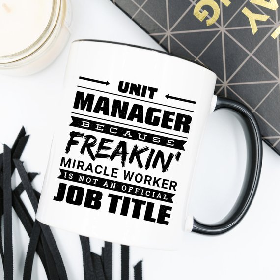 A humorous 11oz coffee mug featuring the phrase 'Unit Manager Because Freakin' Miracle Worker Is Not An Official Job Title' in a stylish font.