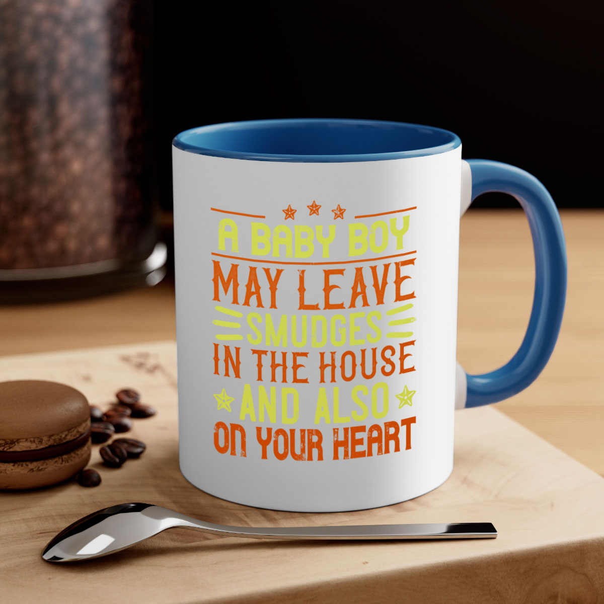 A stylish two-tone ceramic mug with a colored handle and glossy finish, perfect for coffee or tea, featuring the phrase 'A baby boy may leave smudges in the house and also on your heart.'