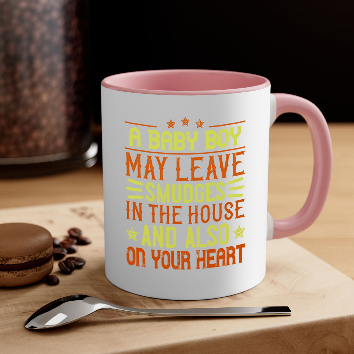 A stylish two-tone ceramic mug with a colored handle and glossy finish, perfect for coffee or tea, featuring the phrase 'A baby boy may leave smudges in the house and also on your heart.'