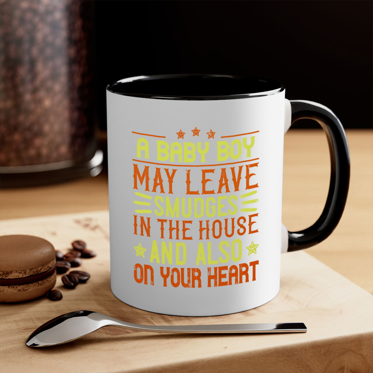 A stylish two-tone ceramic mug with a colored handle and glossy finish, perfect for coffee or tea, featuring the phrase 'A baby boy may leave smudges in the house and also on your heart.'