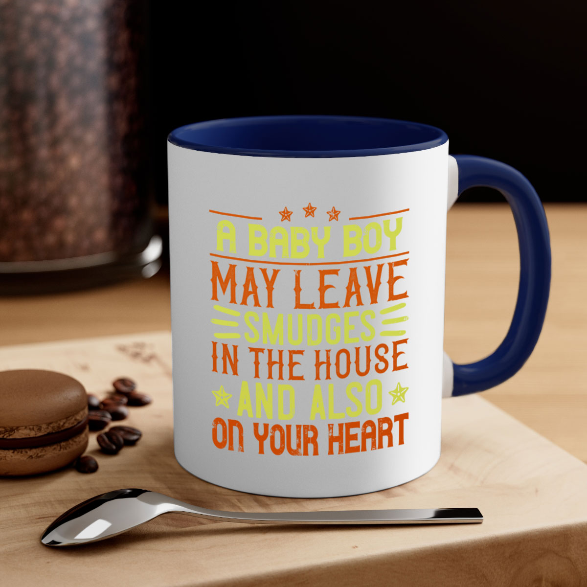 A stylish two-tone ceramic mug with a colored handle and glossy finish, perfect for coffee or tea, featuring the phrase 'A baby boy may leave smudges in the house and also on your heart.'