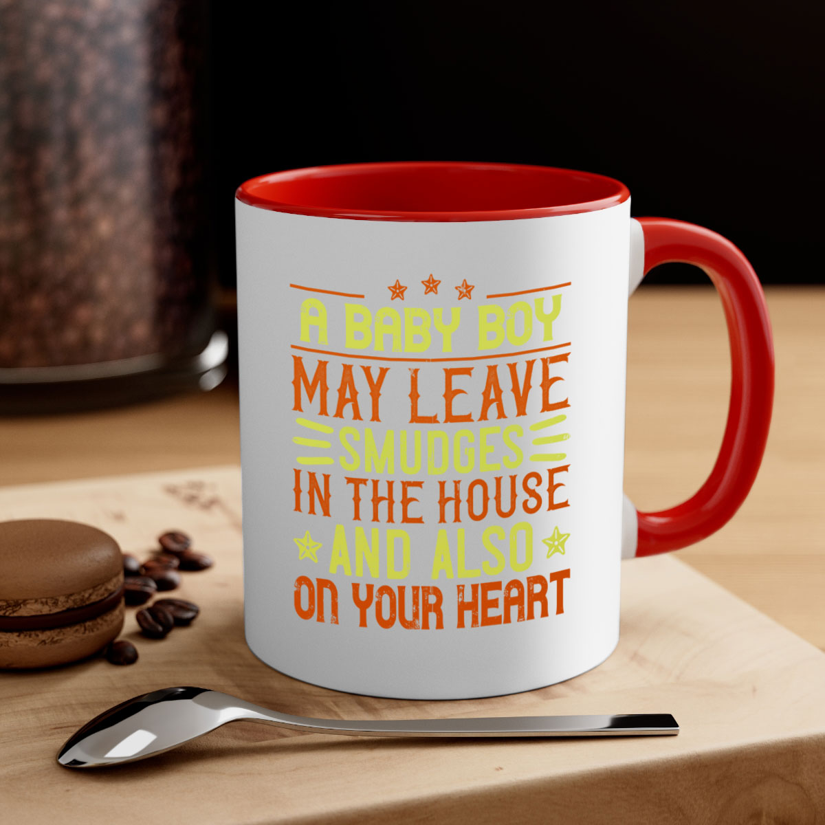 A stylish two-tone ceramic mug with a colored handle and glossy finish, perfect for coffee or tea, featuring the phrase 'A baby boy may leave smudges in the house and also on your heart.'