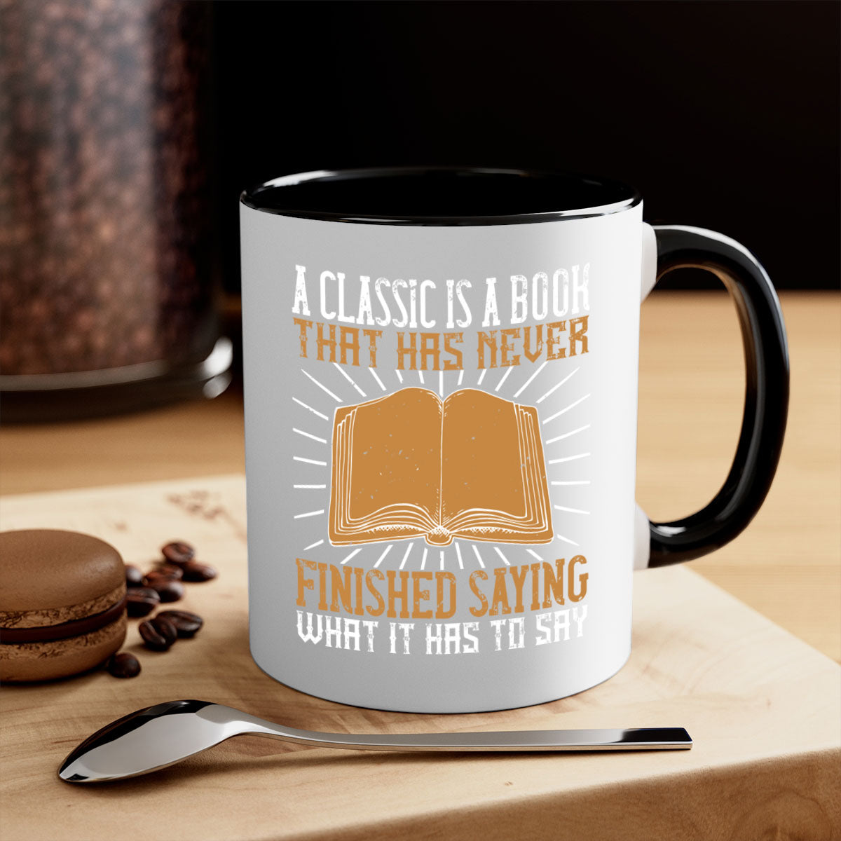 A two-tone ceramic mug featuring a colored handle and interior, showcasing the phrase 'A Classic is a Book That Has Never Finished Saying What It Has to Say'.