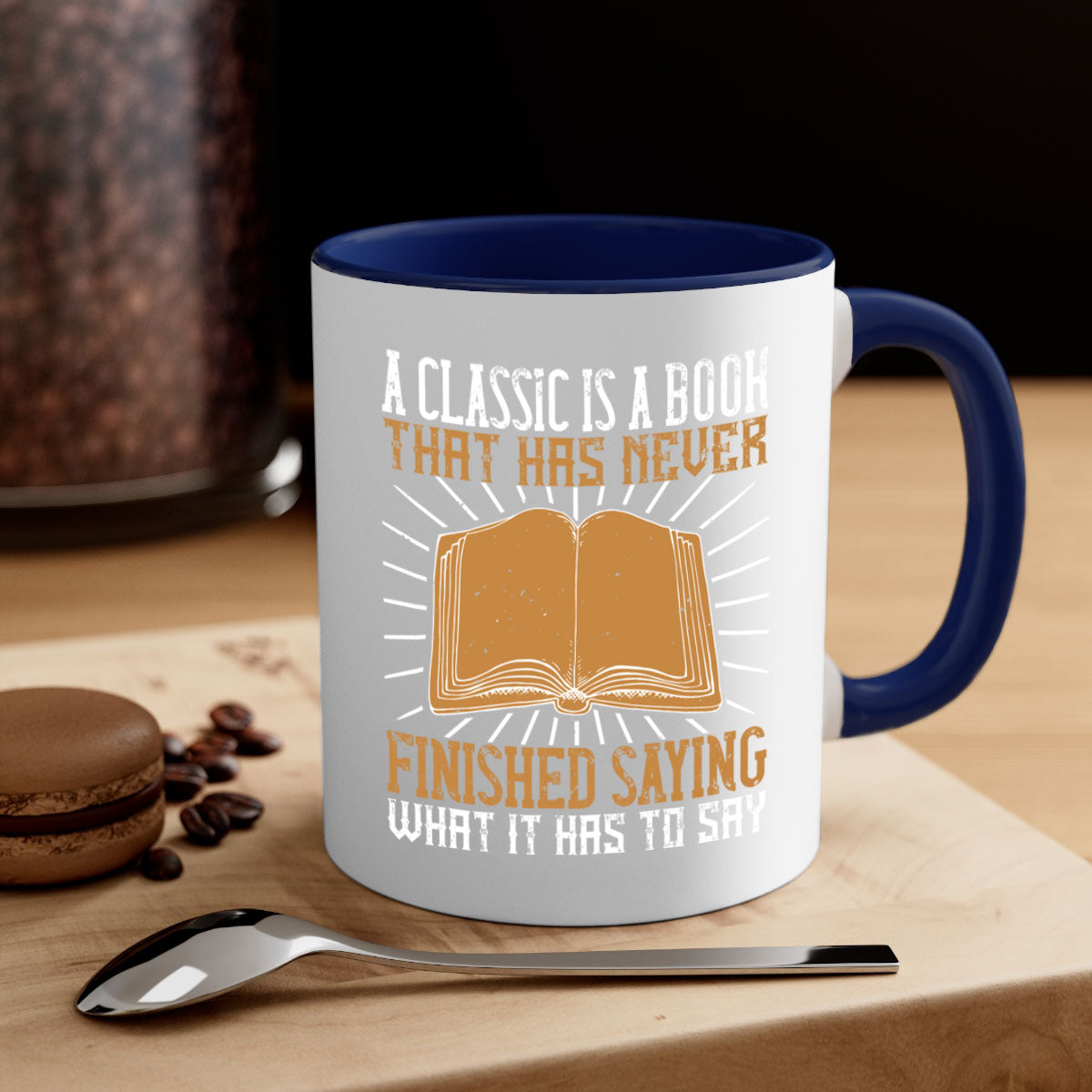 A two-tone ceramic mug featuring a colored handle and interior, showcasing the phrase 'A Classic is a Book That Has Never Finished Saying What It Has to Say'.