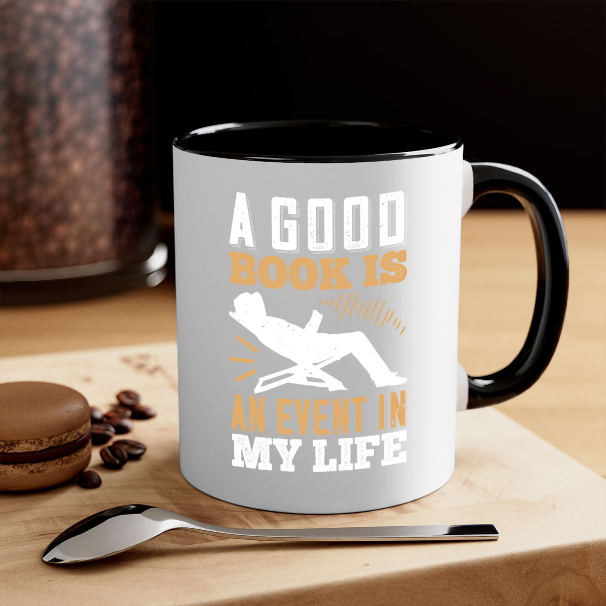 A stylish two-tone ceramic mug with a colored handle and interior, featuring the phrase 'A Good Book is an Event in My Life'.