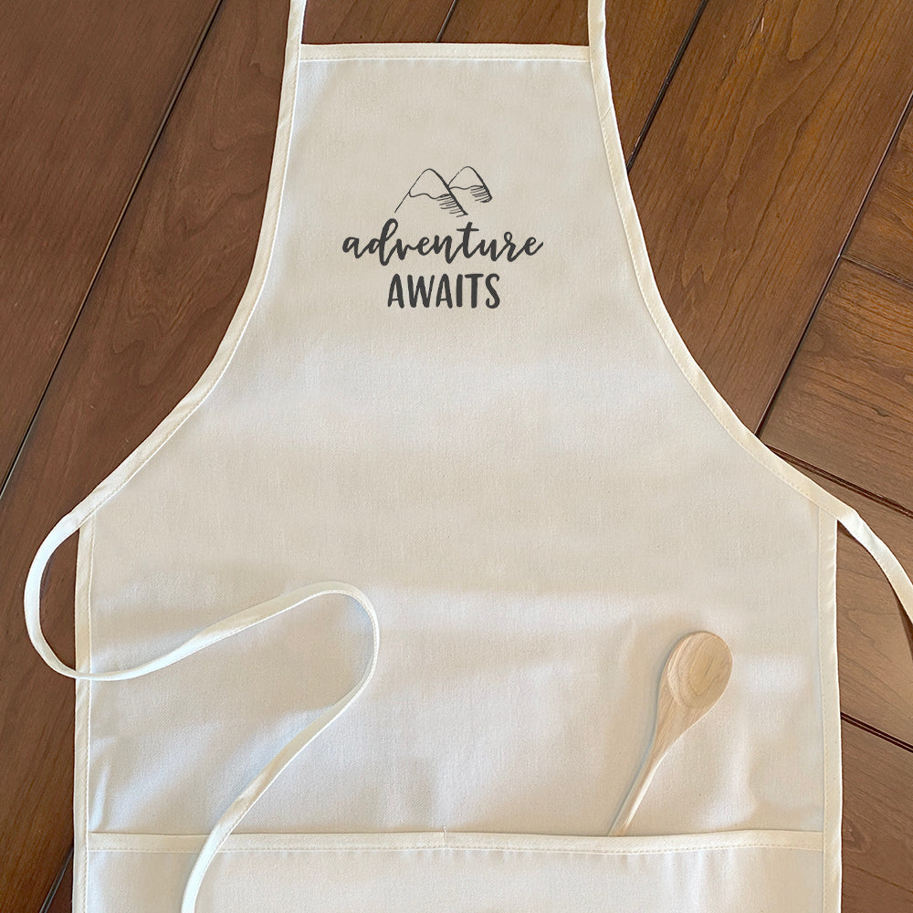 Adventure Awaits Women's Apron featuring a mountain design, made of cotton canvas with adjustable neck and twill ties.