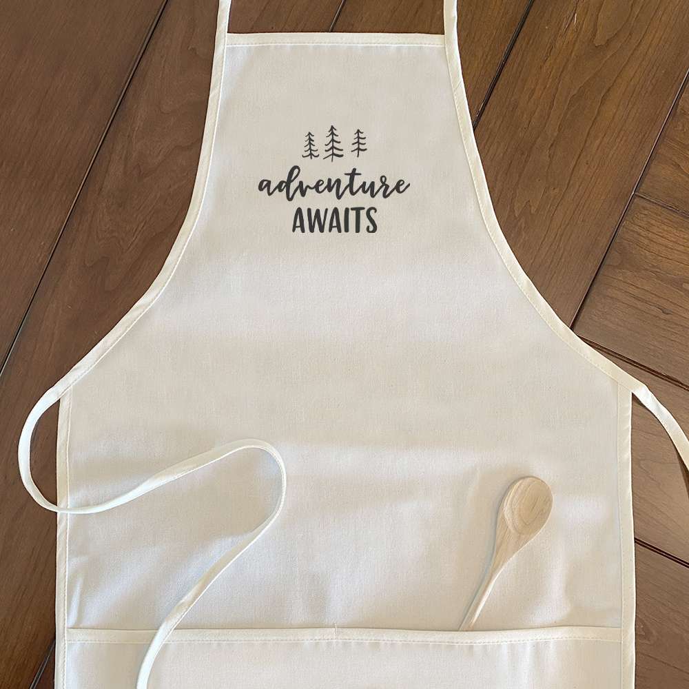 Adventure Awaits Women's Apron featuring a tree design, made of cotton canvas with adjustable neck and twill ties.