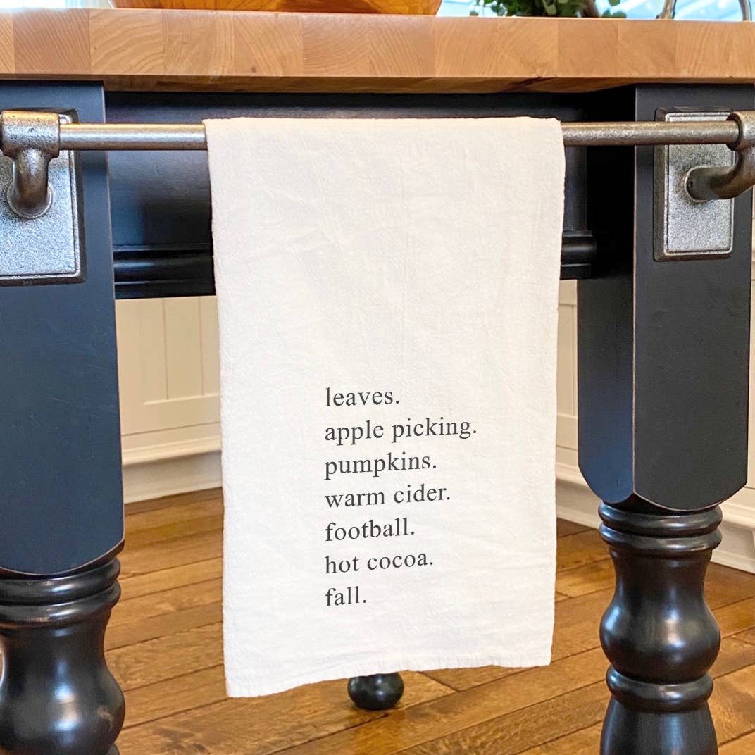 All Things Fall cotton tea towel featuring vibrant autumn designs, hemmed edges, and a square shape, perfect for kitchen use.