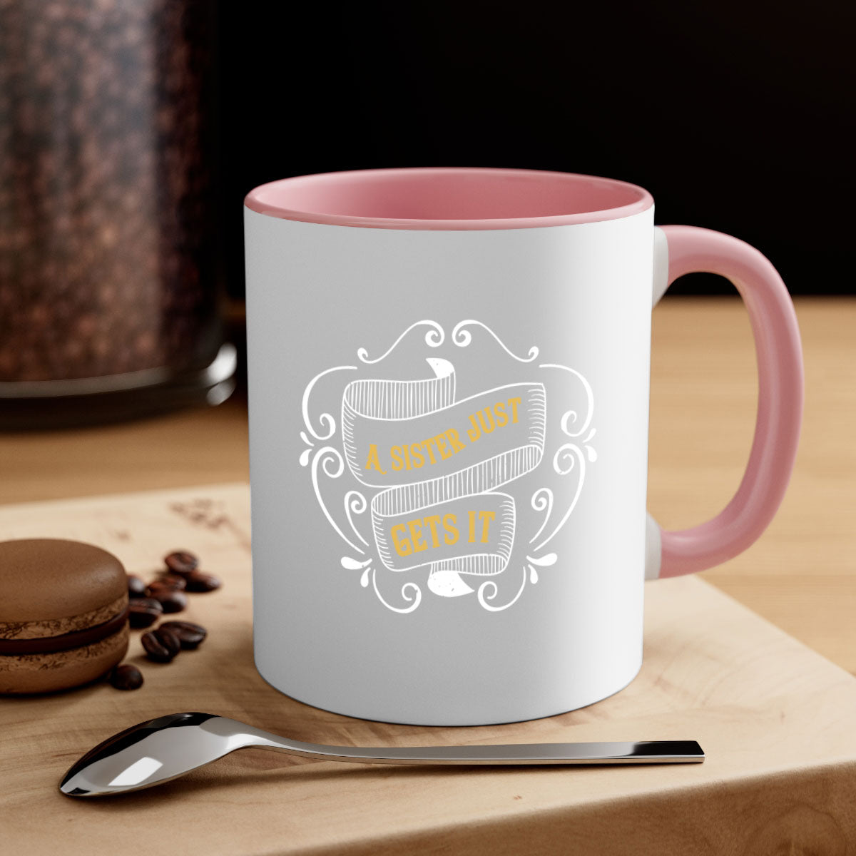 Two-tone ceramic coffee mug with colorful handle and interior, featuring the phrase 'All You Need Is Love… and a Sister'.