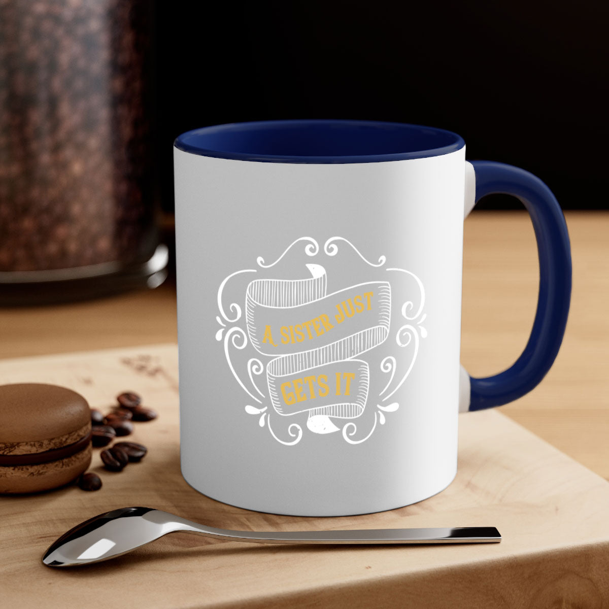 Two-tone ceramic coffee mug with colorful handle and interior, featuring the phrase 'All You Need Is Love… and a Sister'.