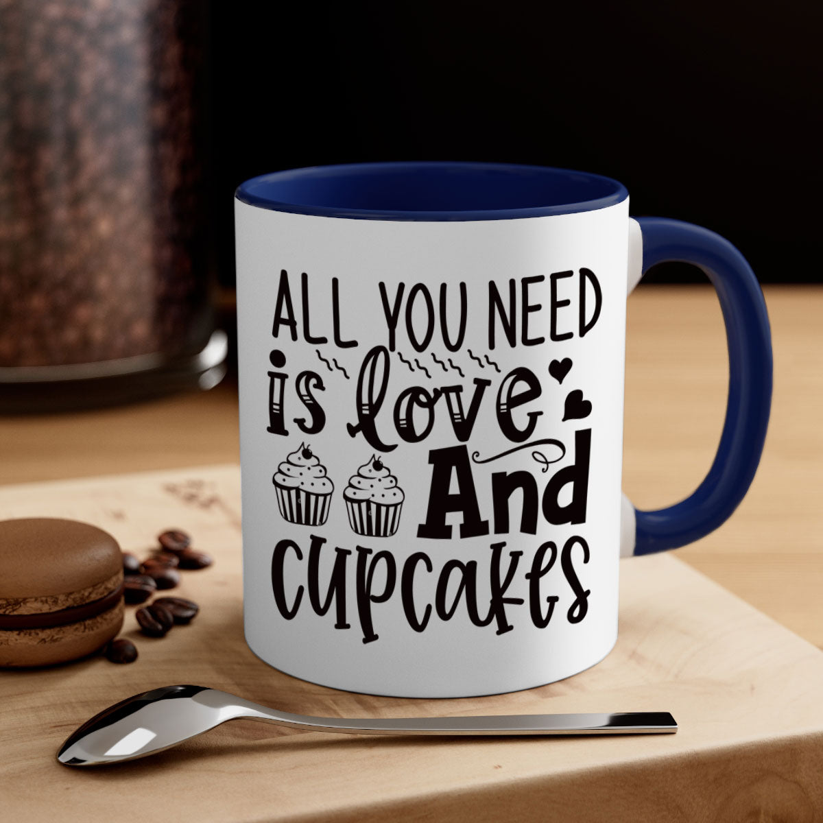 A colorful two-tone ceramic mug with the phrase 'All You Need Is Love and Cupcakes' printed on it, featuring a glossy finish and a C-shaped handle.