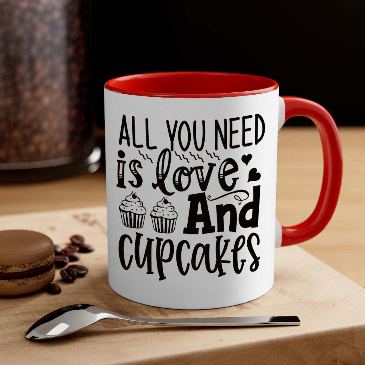 A colorful two-tone ceramic mug with the phrase 'All You Need Is Love and Cupcakes' printed on it, featuring a glossy finish and a C-shaped handle.