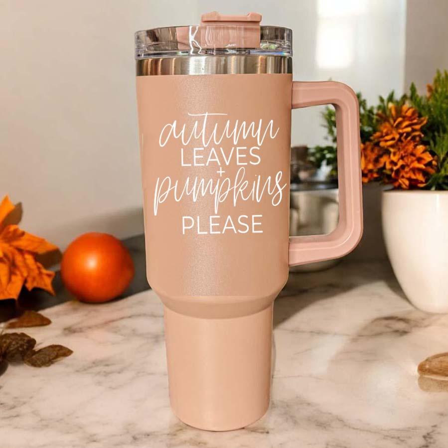 A stylish 40oz tumbler featuring an autumn leaves design with the phrase 'Autumn Leaves + Pumpkins Please', perfect for fall beverages.