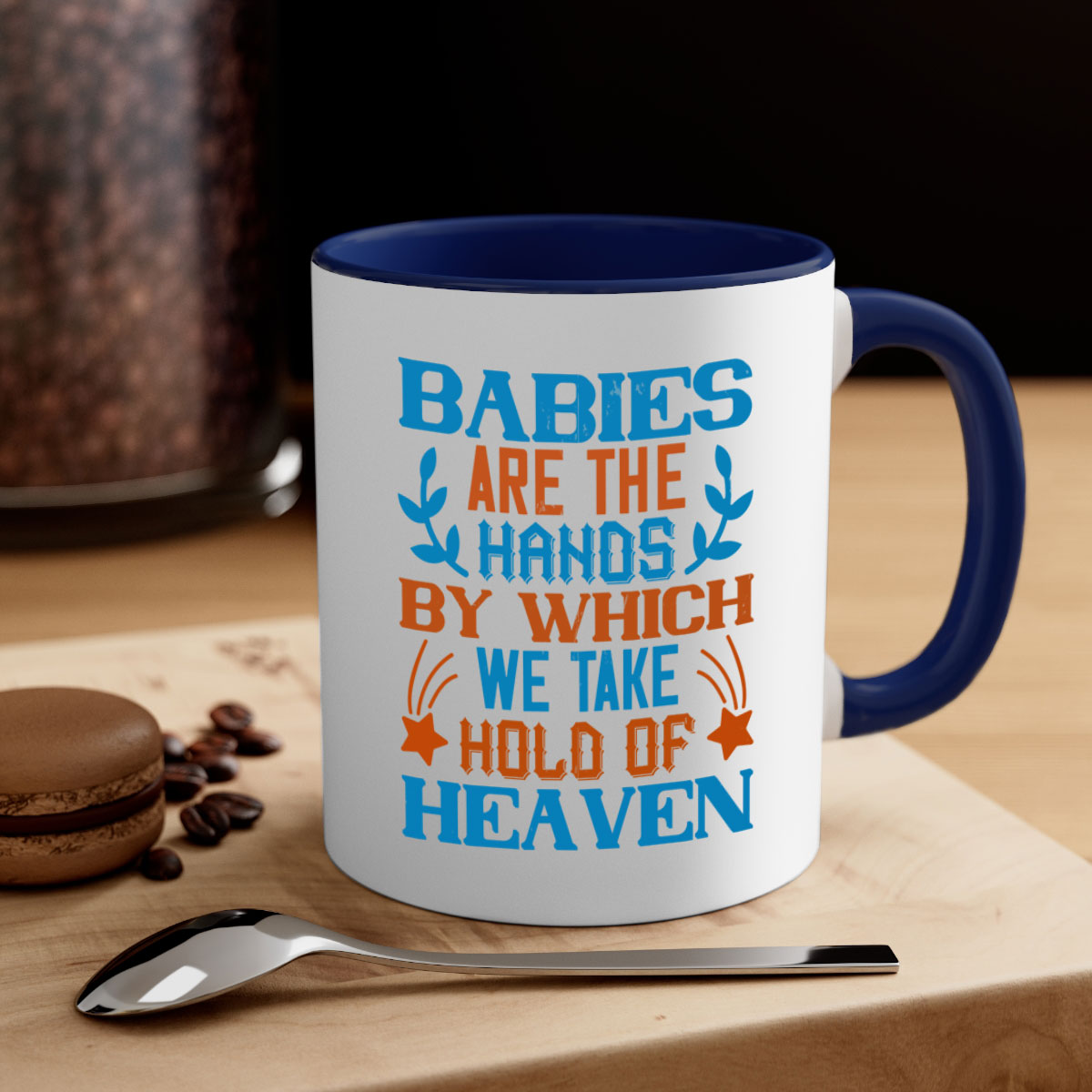 A stylish two-tone ceramic mug with a colored handle and interior, featuring the phrase 'Babies are the hands by which we take hold of heaven'.