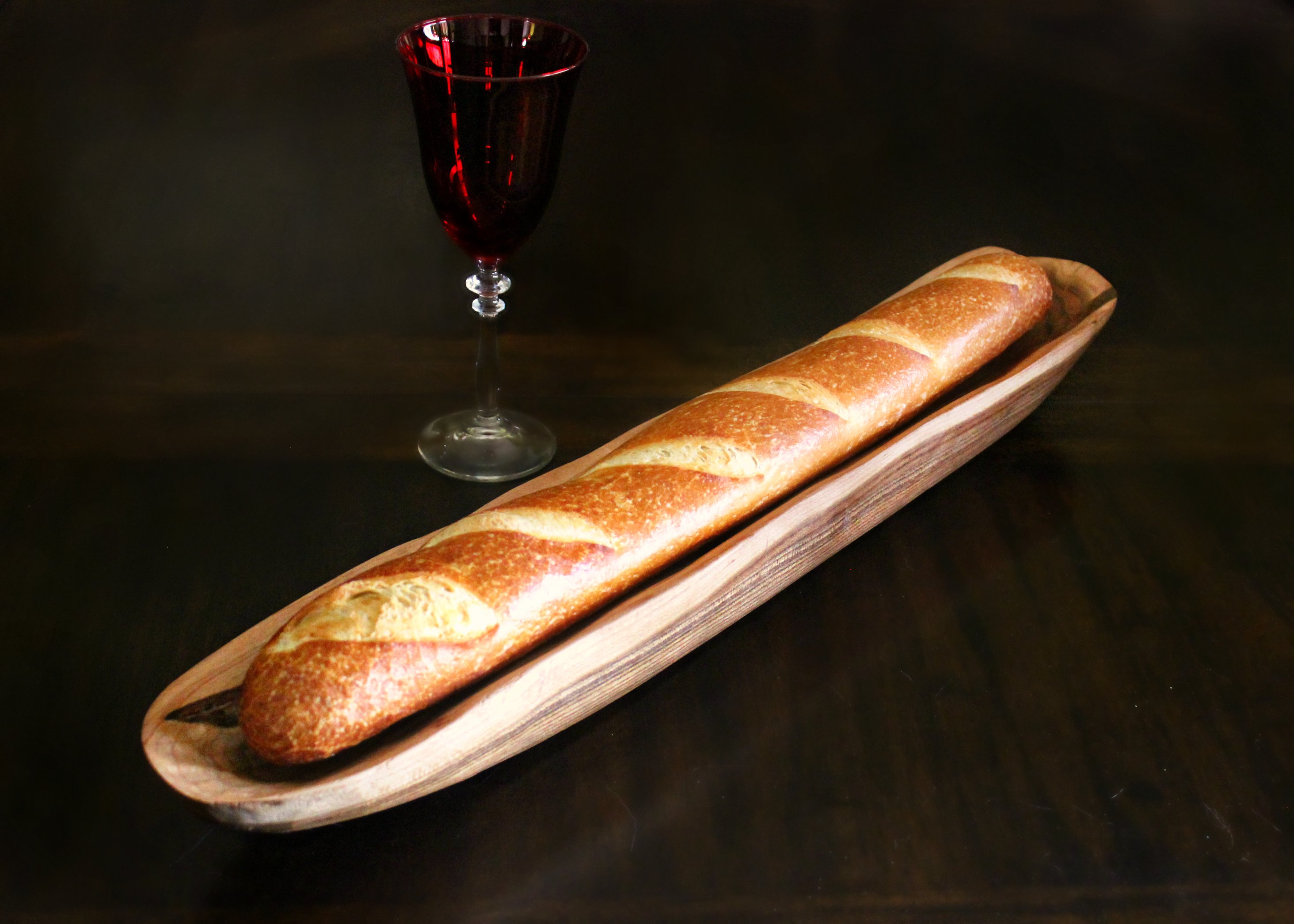 Handcarved baguette tray made from Cherry/Maple or Walnut/Maple, measuring 33 inches long, showcasing elegant craftsmanship.