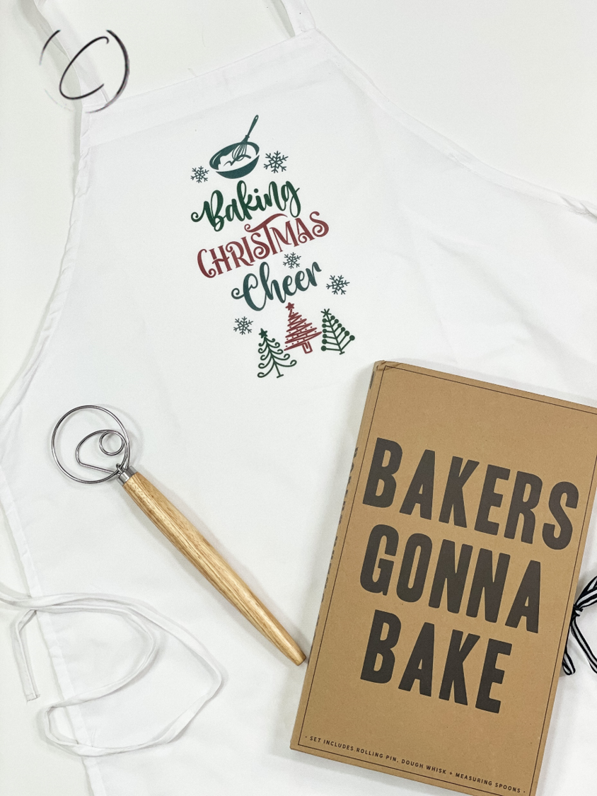 Baking Christmas Cheer Apron featuring festive design, full-length cut, and long waist ties, perfect for holiday cooking.